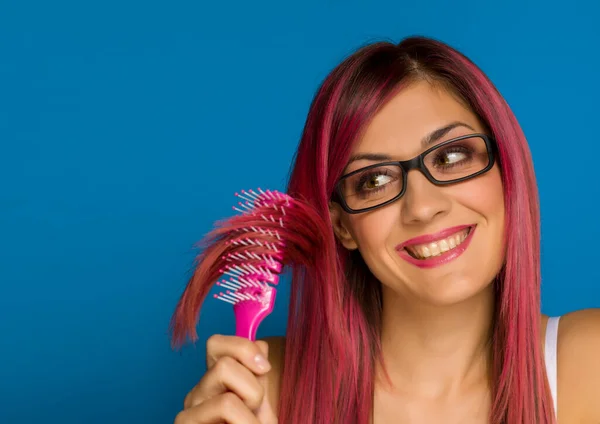 年轻快乐的女人用蓝色衬托着粉红的头发 — 图库照片