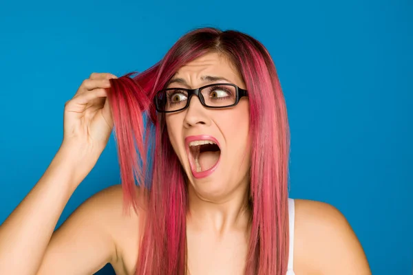 Joven Mujer Conmocionada Con Pelo Rosa Sobre Fondo Azul —  Fotos de Stock