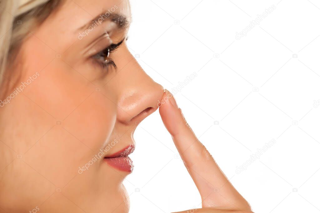 profile of young woman, touching her nose