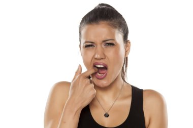 Beyaz arka planda ağrıyan dişlerde güzel genç bir kadın görünüyor.