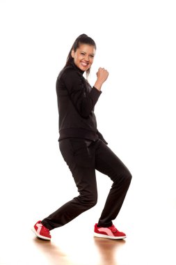 Stüdyoda beyaz arka planda poz veren eşofmanlı güzel bir kadın.