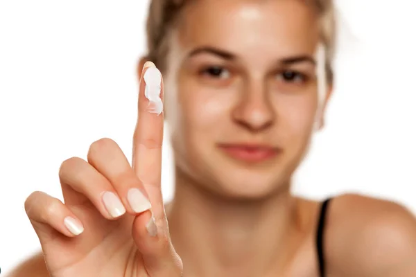 Joven Mujer Sonriente Mostrando Una Crema Dedo Sobre Fondo Blanco — Foto de Stock