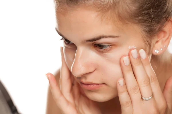 Jeune Femme Appliquant Crème Sur Son Visage Sur Fond Blanc — Photo