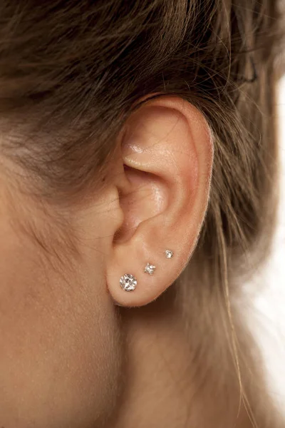 Closeup Female Ear Three Earrings — Stock Photo, Image