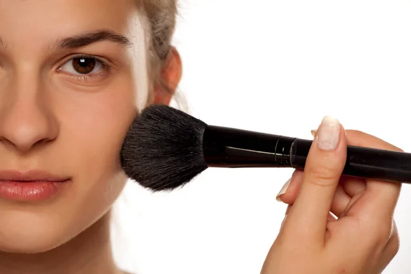 Mujer Joven Aplicando Base Polvo Con Pincel Sobre Fondo Blanco — Foto de Stock