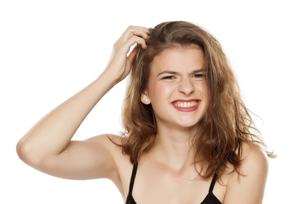 Beyaz Arka Planda Başını Kaşıyan Genç Bir Kadın — Stok fotoğraf
