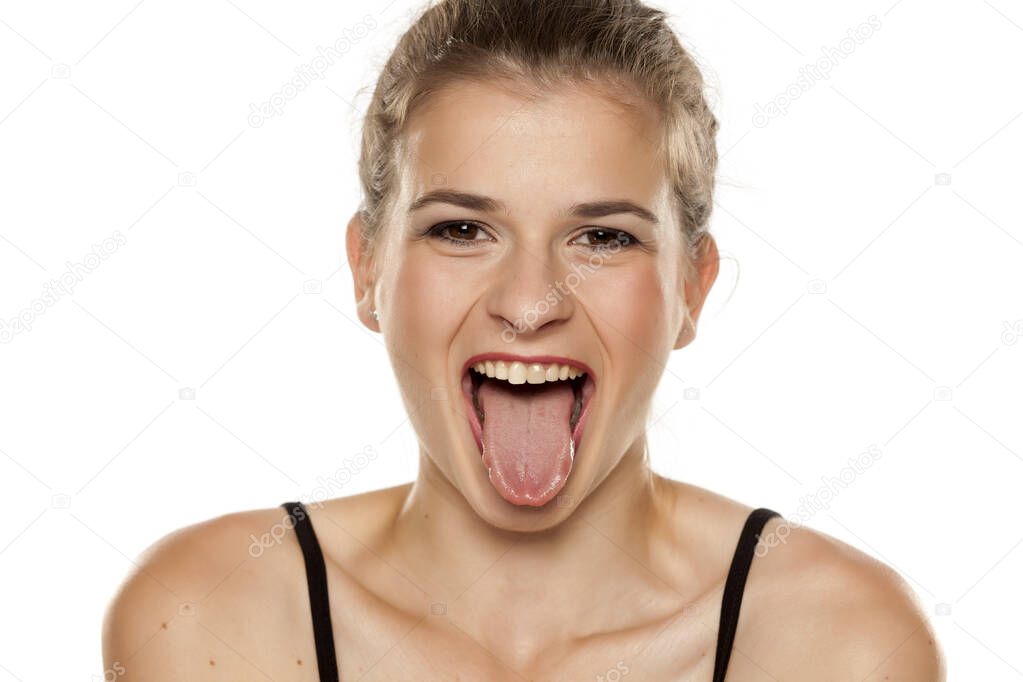 young woman with her tongue out on white background