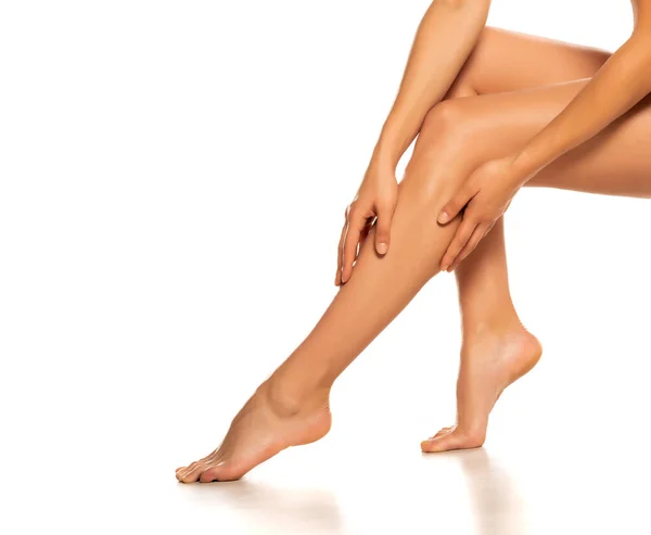 Женщина Трогает Красиво Ухоженные Женские Ноги Белом Фоне — стоковое фото