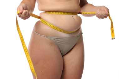 Obez kadının, kilo kaybı ve beyaz arka planda vücut ölçüsü için bant ile bel yağını sıkarkenki stüdyo fotoğrafı.