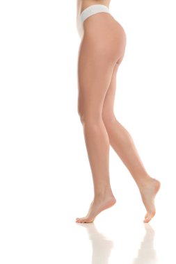 Beyaz iç çamaşırlı kadın bacakları ve kalçalarının stüdyo fotoğrafları beyaz arka planda parmak uçlarında çıplak ayakla yürümeleri.