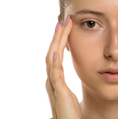 Stüdyo, beyaz arka planda genç bir kadının yüzlerine dokunuşunun yakın plan çekimini yaptı.