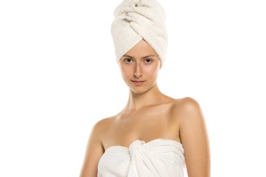 Bedeninde havlu, beyaz arka planda kafası olan genç bir kadının stüdyo fotoğrafı.