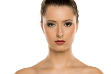 Zarif bir akşam makyajı ve temiz bir saç stili olan güzel bir kadının portresi. Kendine güvenen ifade, kusursuz cilt ve beyaz arka planda büyüleyici bir görünüm.