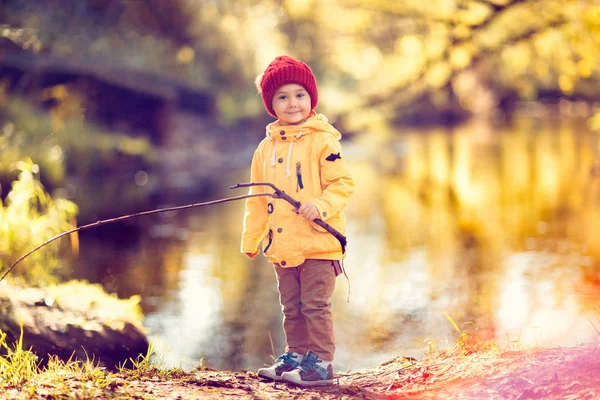 Usměvavý Chlapec Drží Dřevěný Proutek Stojí Břehu Jezera — Stock fotografie
