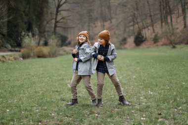 Ormanda birlikte eğleniyor kardeşler gülümseyen 