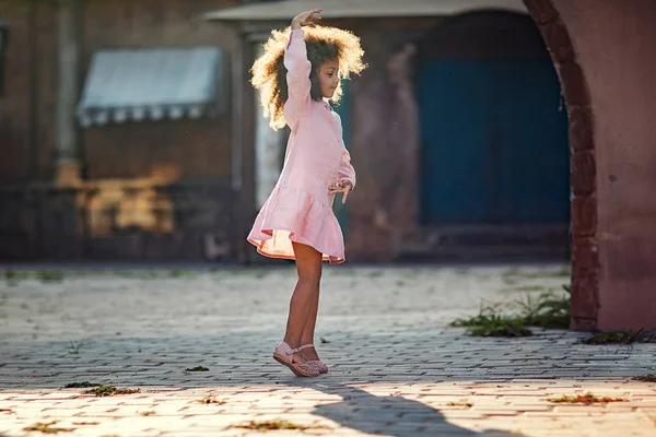 small girl dancing on the street of old town