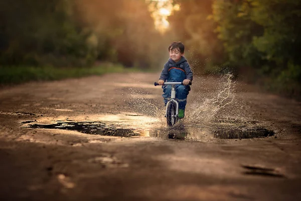 Lycklig Pojke Ridning Cykel Genom Pöl Hösten — Stockfoto