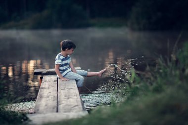 küçük çocuk su göle ayaklı ahşap iskelesi oturan 