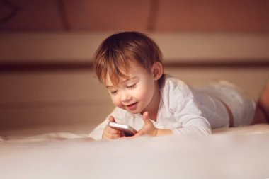 mutlu çocuk evde yerde yatarken smartphone vasıl arıyorsunuz