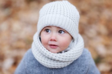 örgü şapkalı çocuk ve arka planda sarı yaprakları ile sonbahar park eşarp portre kadar kapatın 