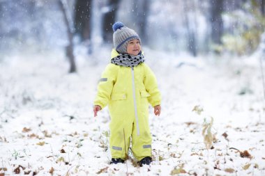tam uzunlukta atış sarı snowsuit ayakta karlı Park mutlu çocuk 