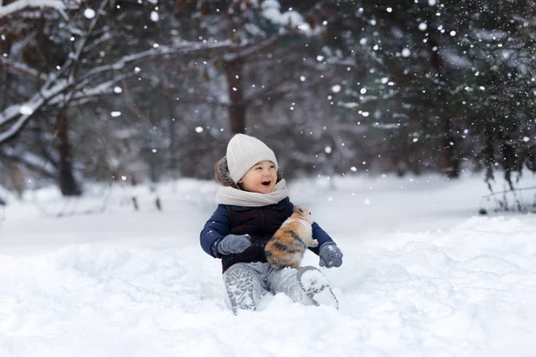 Счастливый Мальчик Сидящий Снегу Парке Зимой Кроликом — стоковое фото