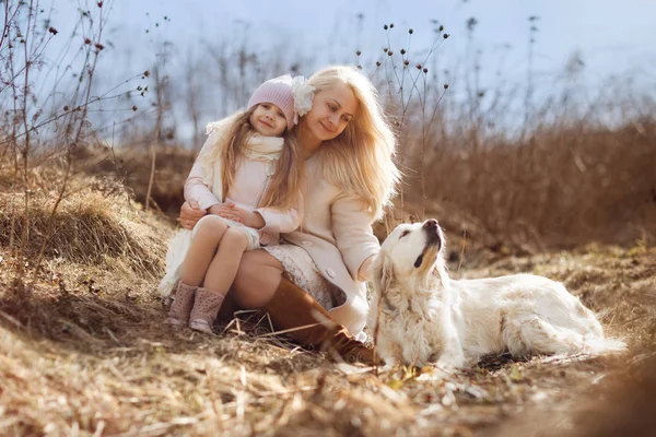 女儿坐在母亲圈户外与金色猎犬 — 图库照片