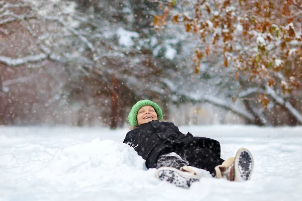 冬天躺在雪地里的笑男孩 — 图库照片
