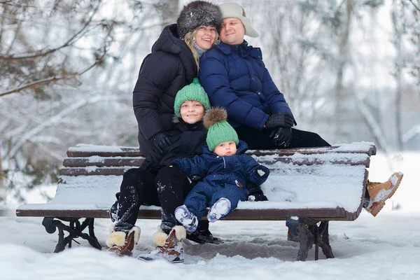 Семья Двумя Детьми Сидящими Деревянной Скамейке Парке Зимой — стоковое фото