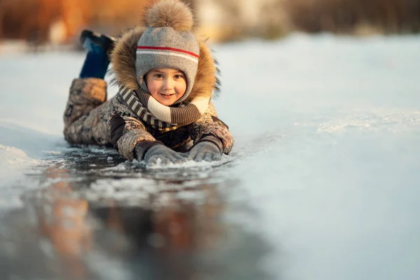 Lycklig Pojke Liggande Isen Sökvägen Och Tittar Kameran — Stockfoto