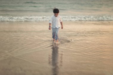 gün batımında sahilde dalgalar deniz üzerinde yürüyen çocuk 