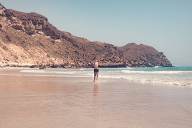 tropik sahilde okyanus tarafından çalışan neşeli beyaz çocuk 