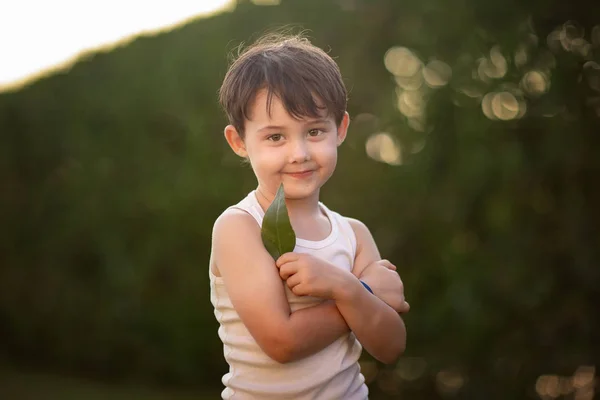 Портрет Усміхненого Хлопчика Який Дивиться Камеру Тримає Зелений Лист Саду — стокове фото