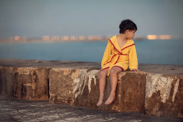 Chłopiec Siedzi Granicy Betonu Patrząc Wstecz Morzu Wieczór — Zdjęcie stockowe