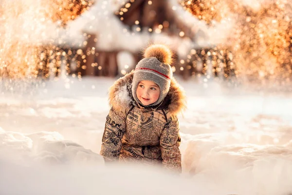 Menino Alegre Sentado Snowdrift Olhando Para Longe Com Luzes Festivas — Fotografia de Stock