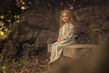 açık havada bankta oturan gülümseyen kız yan görünümü 