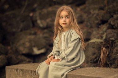 kız taş bankta açık havada oturan ve uzağa bakıyor