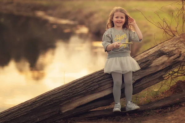 Meisje Met Lollipop Leunend Log Glimlacht Camera Het Aanraken Van — Stockfoto