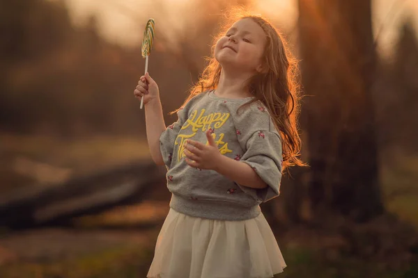 Porträtt Girl Holding Lollipop Utomhus Med Suddig Bakgrund — Stockfoto