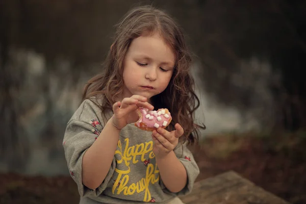 Portret Van Meisje Eten Donut Zittend Houten Bankje Het Park — Stockfoto