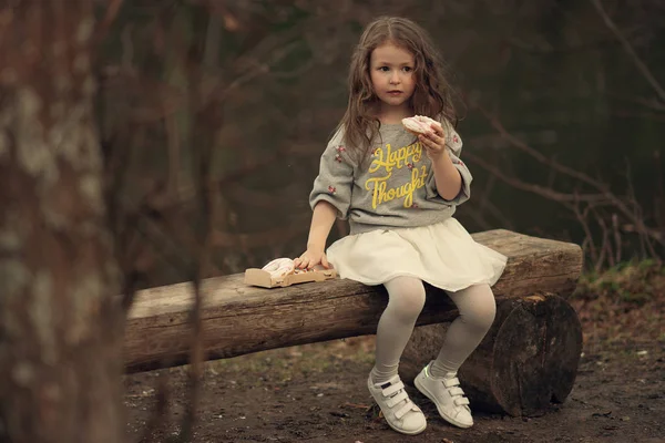 Ernstig Meisje Houdt Donut Haar Hand Kijkt Weg Het Park — Stockfoto