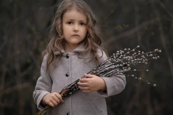 柳の花を持ち カメラを見ている真剣な女の子の肖像画 — ストック写真