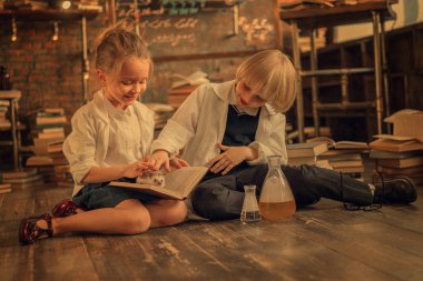 sınıfta kirpi okşayarak beyaz önlüklü erkek ve kız 