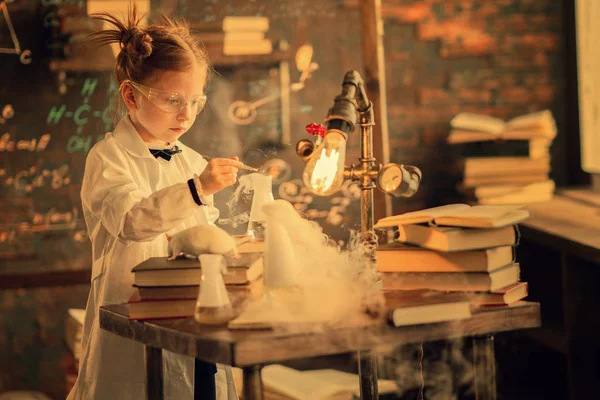 schoolchild studying chemistry with test tubes in laboratory