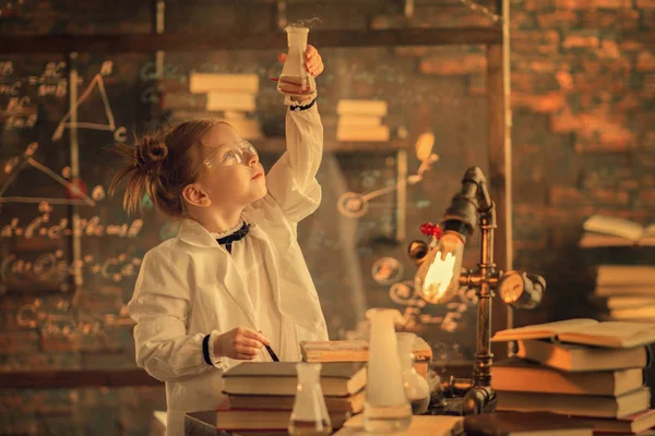 küçük araştırmacının laboratuvarda test tüpüne bakan portresi  