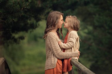 parkta anne ve kızı dokunmadan burunları yan görünümü 