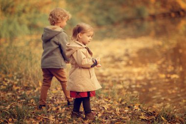 Nehirde duran iki çocuğun tam boy çekimi. 