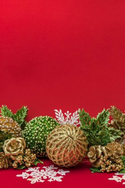 Kırmızı arka plan üzerinde altın, beyaz ve yeşil Noel dekorasyonu