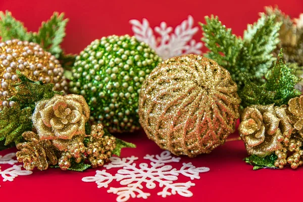 Kırmızı arka plan üzerinde altın, beyaz ve yeşil Noel dekorasyonu