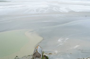 kuma mudflat, ünlü Mont Saint Michel manastırda, düşük tide çevresinde üzerinde yürüyen turist bir grup vizyon.
